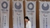 FILE - Tokyo's first woman Governor Yuriko Koike walks past Tokyo 2020 Olympic and Paralympic Games flags as she goes onstage to make a speech at Tokyo Metropolitan Government Building in Tokyo, Japan, August 2, 2016. 