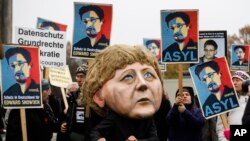 ABD istihbarat servisi NSA'nın telefon dinlemesini Başbakan Merkel'in maskesini takarak protesto eden bir Alman gösterici