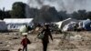 Migrants carry their belongings as they leave from a makeshift camp during a police operation at the Greek-Macedonian border near the northern Greek village of Idomeni, May 26, 2016. 