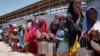FILE - In this photo taken Feb. 25, 2017, displaced Somali girls who fled the drought in southern Somalia stand in a queue to receive food handouts at a feeding center in a camp in Mogadishu, Somalia.