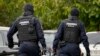 Police wearing balaclavas hold a battering ram used to break down a door outside the residence of internet influencer Andrew Tate during an early morning police search raid, on the outskirts of Bucharest, Romania, Aug. 21, 2024. 