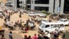 Drivers of motorcycle taxis, known locally as boda-bodas, ride with passengers on a street of Kampala, Uganda, on July 18, 2024. 
